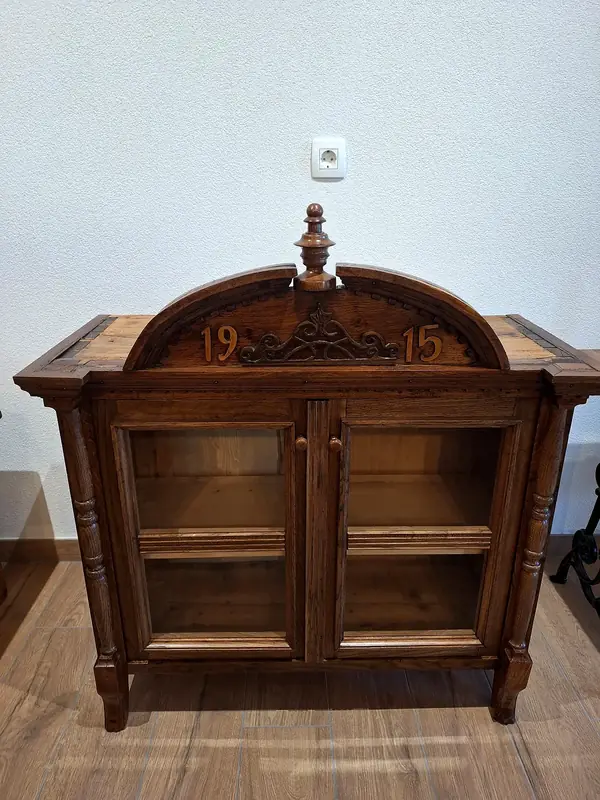 Vitrina z letnico 1915 na rezbarjeni kroni